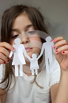 Little girl holds paper chain family; broken family or divorce c