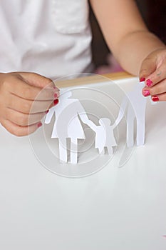 Little girl holds paper chain family; happy or broken family co