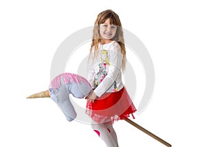 Little girl holds a toy ridge between the legs on a white background. Isolated