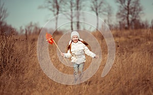 little girl holds windmill in hand