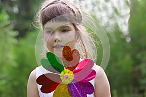 Little girl holds windmill and looks away