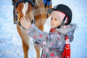 Little girl on a horse in winter, horseback riding