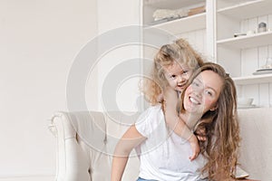 Little girl hugging her mother in the interior