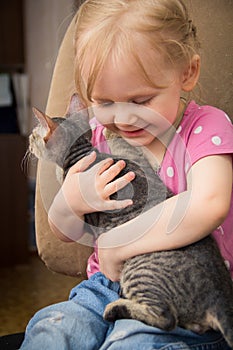 Little girl hugging het cat