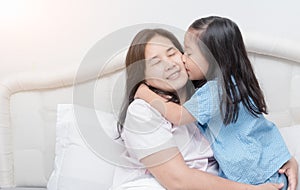 Little girl is hugging and kissing her mom