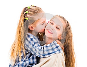 Little girl hugging and kissing her older sister