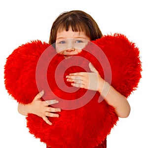 Little girl hugging a large toy heart