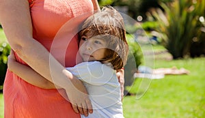 Little girl hugging mather in the park