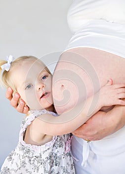 Little Girl Hugging Mom's Belly