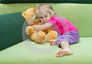 Little girl hugging a Teddy bear.