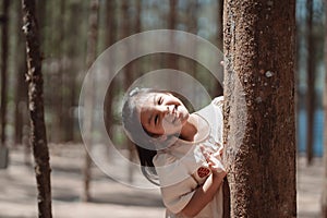 Little girl hugging tree, Saving eco concept, friendly environment in a forest