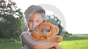 A little girl hugs her favorite toy. A child plays with a Teddy bear. A soft toy in the hands of a baby. A happy kid