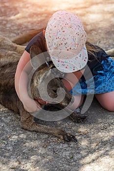 Little girl hugs a kangaroo in Israel zoo