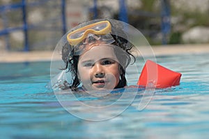 Little girl in inflatable over-sleeves floats