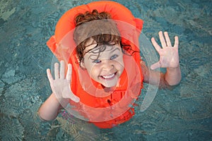 Little girl in inflatable waistcoat in pool photo