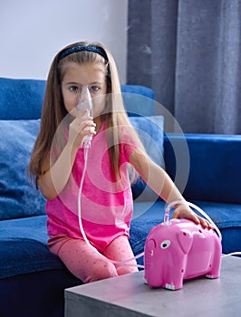 Little girl with inhaler and pink piggy bank