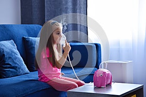 Little girl with inhaler on sofa
