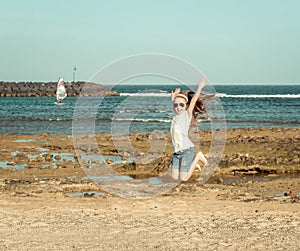 Little girl jump on a beach