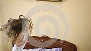 Little girl jumping in bed