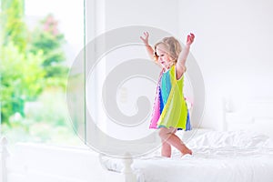 Little girl jumping on a bed