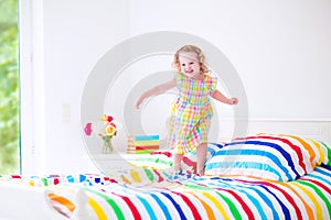 Little girl jumping on a bed