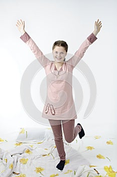 Little girl jumping on bed isolated