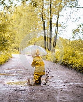 Little girl jumping fun in a dirty puddle