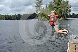 Little girl jumping into lake