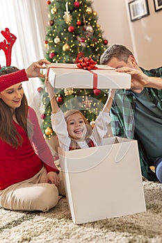 Little girl jumping out giant Christmas gift box