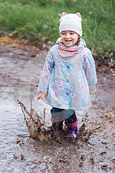 Little girl jumping in the puddle