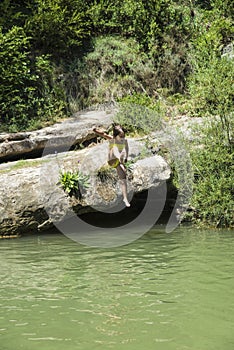 Little girl jumping in a river