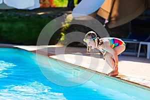 Little girl jumping into swimming pool