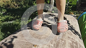 little girl jumping on a trampoline, feet close-up.