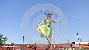 Little girl jumping on a trampoline on the street.