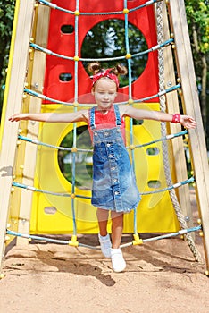 A little girl jumps high up on a children`s playground. happy child walks in summer