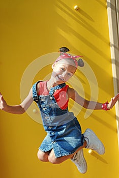 A little girl jumps high up on a children`s playground. happy child walks in summer