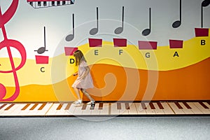 Little girl jumps on musical keys at science museum