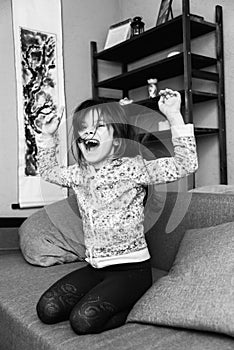 Little girl jumps on a sofa in the room