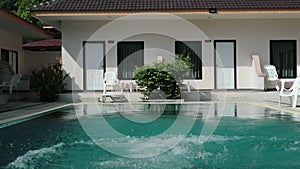 Little girl jumps in a swimming pool. funy time in summer holiday