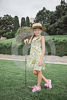 Little girl just swing golf ball on golf course fairway photo