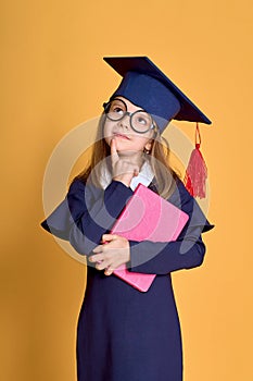 Little girl kid in academician clothes with book