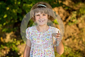 Little girl kid with glass of water in morning, drink every day