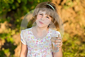 Little girl kid with glass of water in morning, drink every day