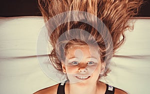 Little girl kid with long hair upside down on sofa