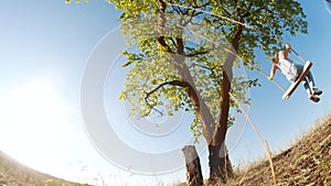 little girl kid swinging on a wooden swing on a tree in fun the park. happy family kid dream concept. little kid girl