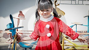 Little Girl kid wearing Santa Claus uniform in the playground, Kid having fun on Christmas holiday time