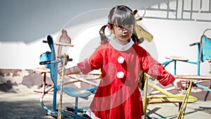 Little Girl kid wearing Santa Claus uniform in the playground, Kid having fun on Christmas holiday time