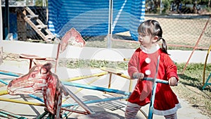 Little Girl kid wearing Santa Claus uniform in the playground, Kid having fun on Christmas holiday time