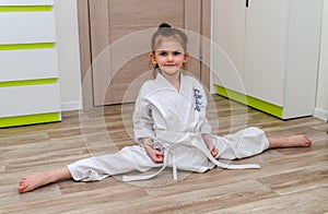 A little girl in a kimono goes in for sports - karate in her room.