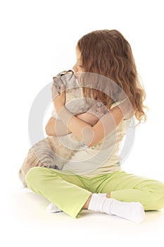 Little girl kisses cat.